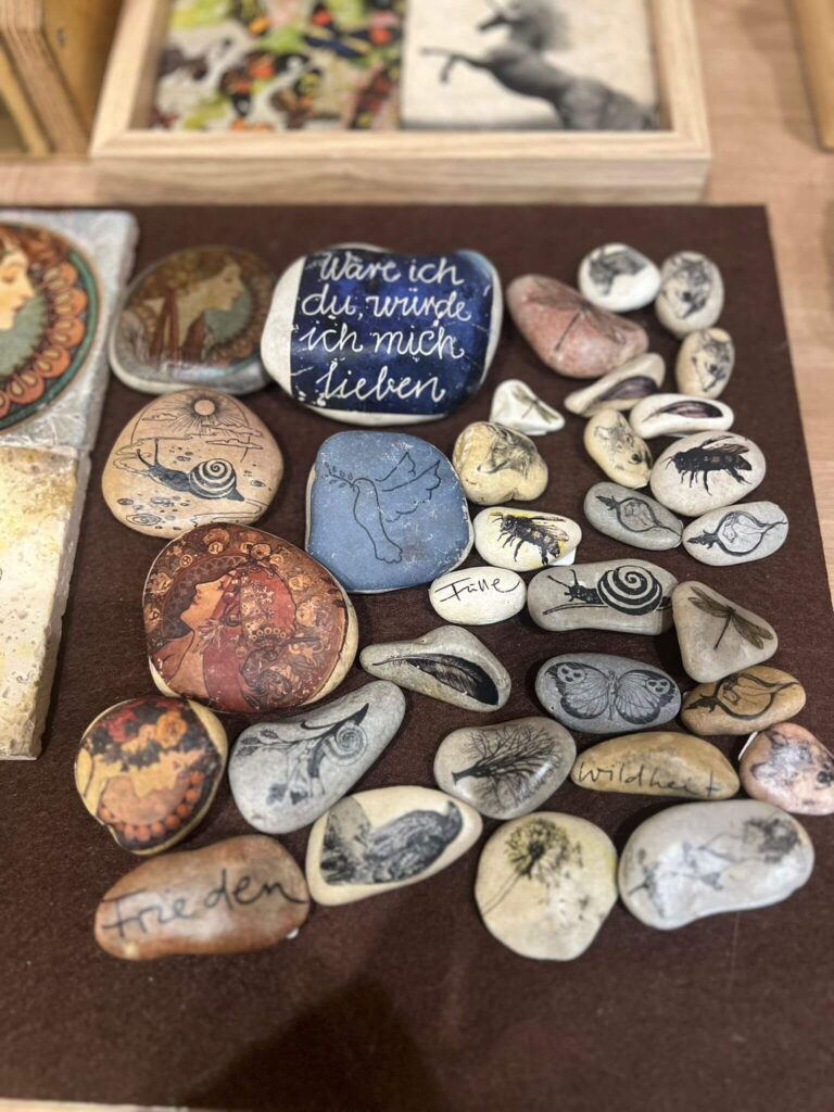 Bemalte Steine mit Motiven und Schriftzügen.