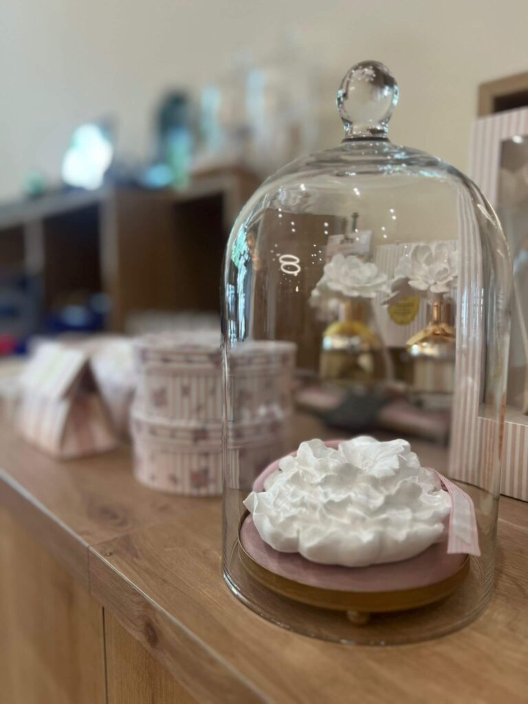 Dekorative Glasglocke mit Blumen auf Holztisch