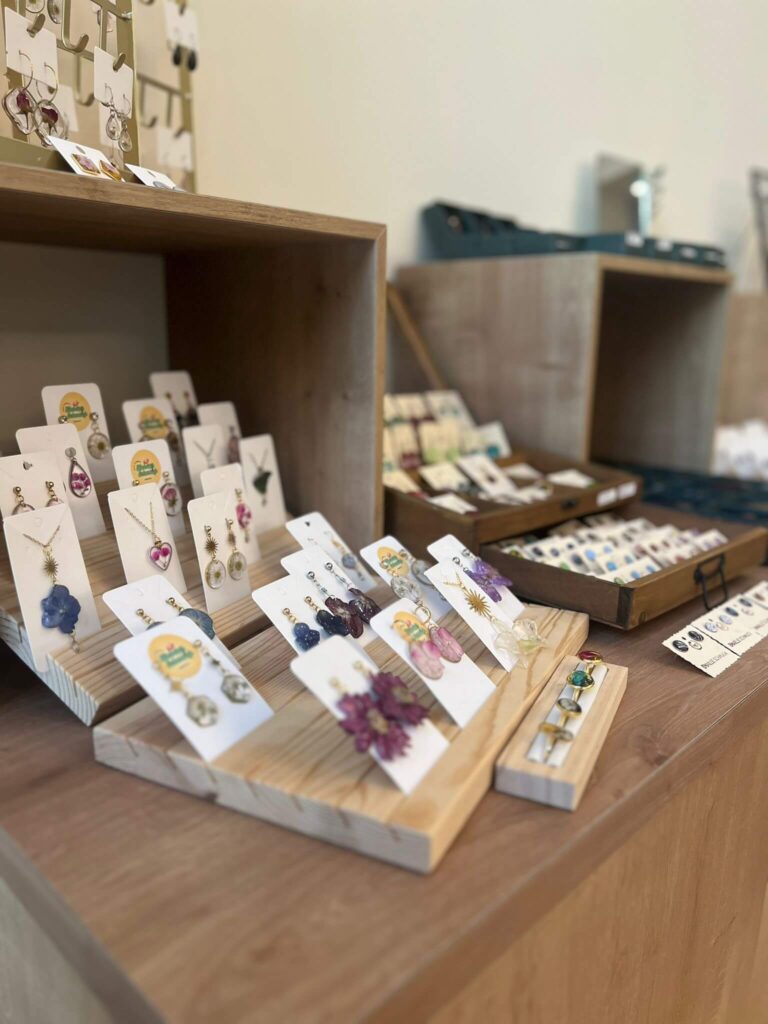 Handgefertigte Ohrringe auf Holzausstellung im Laden.