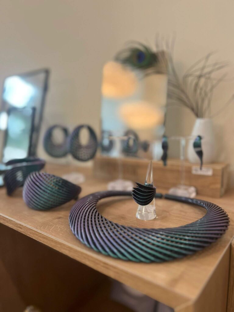 Schmuckdisplay mit Halskette und Armreifen auf Holzregal